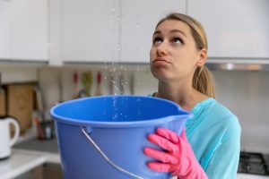 Home,Flooded,By,Upstairs,Or,Roof,Damage,-,Woman,Holding